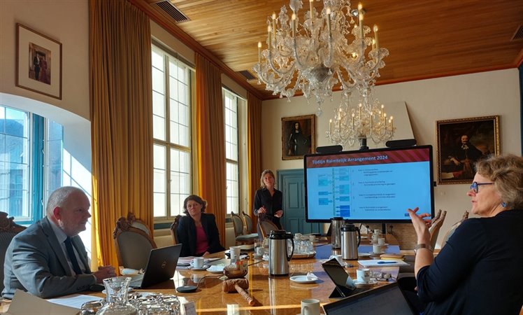 Marjolein Jansen aan tafel met Dick van der Velde (gedeputeerde provincie Zeeland), Renske de Jong (programmamanager Fysieke Leefomgeving provincie Zeeland) en (staande) Madeline Buining (strategisch adviseur Novex/Ruimtelijke arrangementen).
