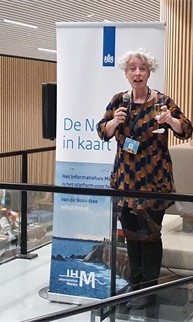 Barbara geeft een presentatie voor een poster van het IHM